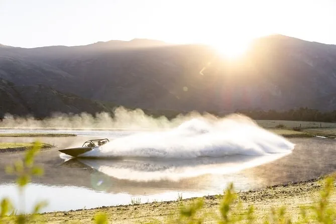 A sprint boat throwing spray at sunrise