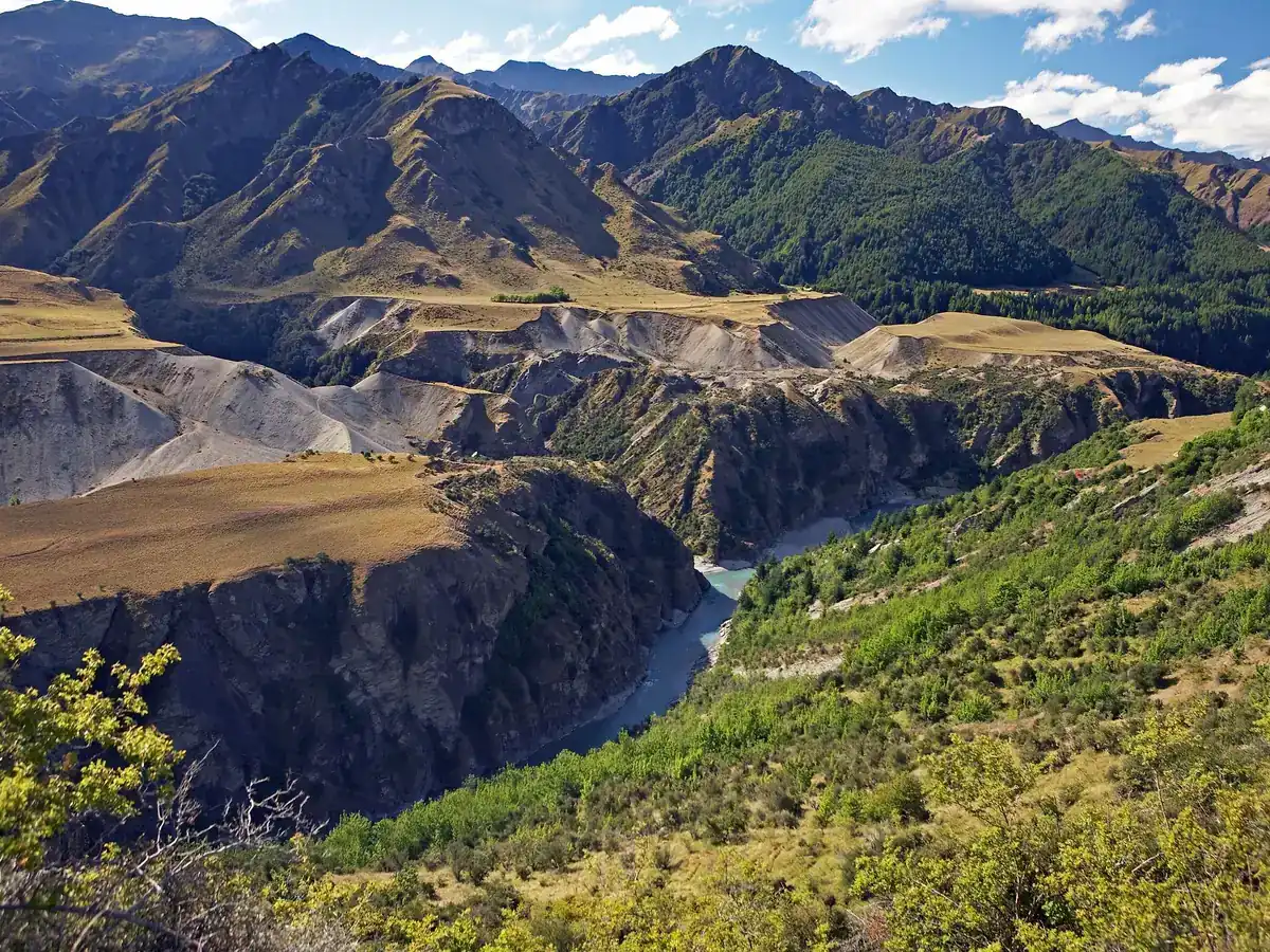 The Shotover River winding through a deep gorge between golden tussock hills